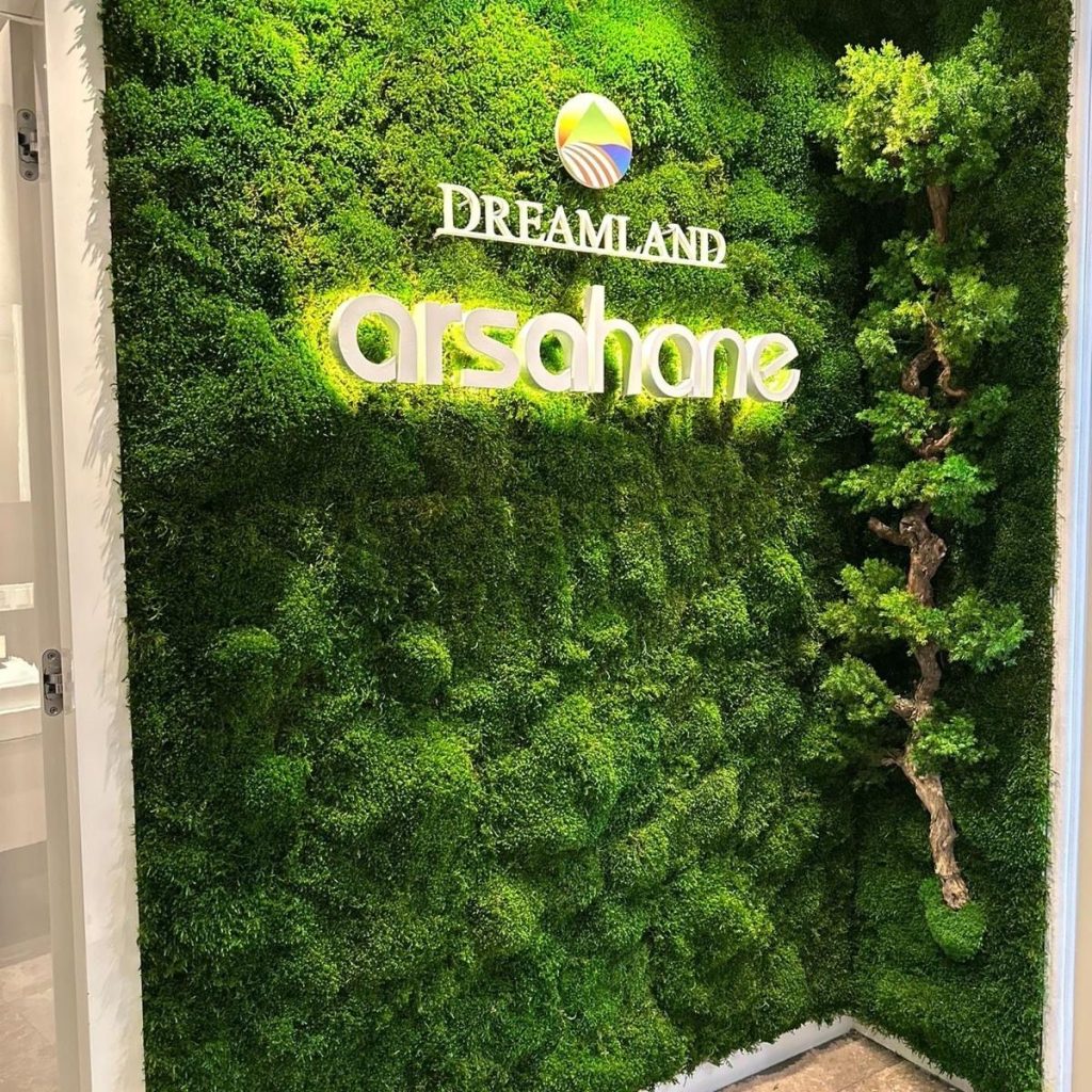 Firma logosu arkasına uygulanan dekoratif stabilize yosun duvar tasarımı.